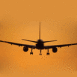 Avion de ligne atterissant au coucher du soleil de dos